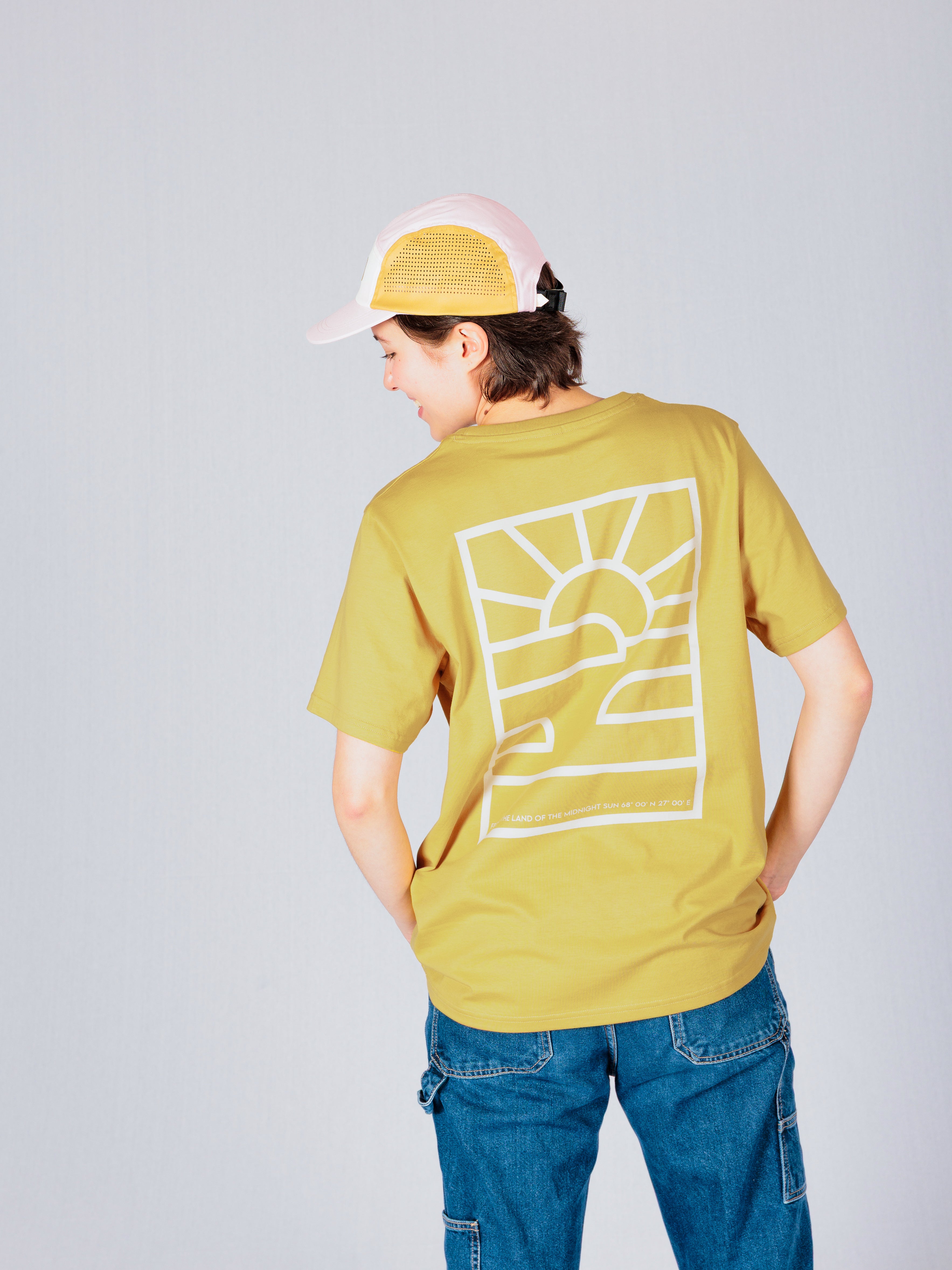 Person in yellow t-shirt with sun graphic and jeans, wearing a pink cap, facing away from the camera.
