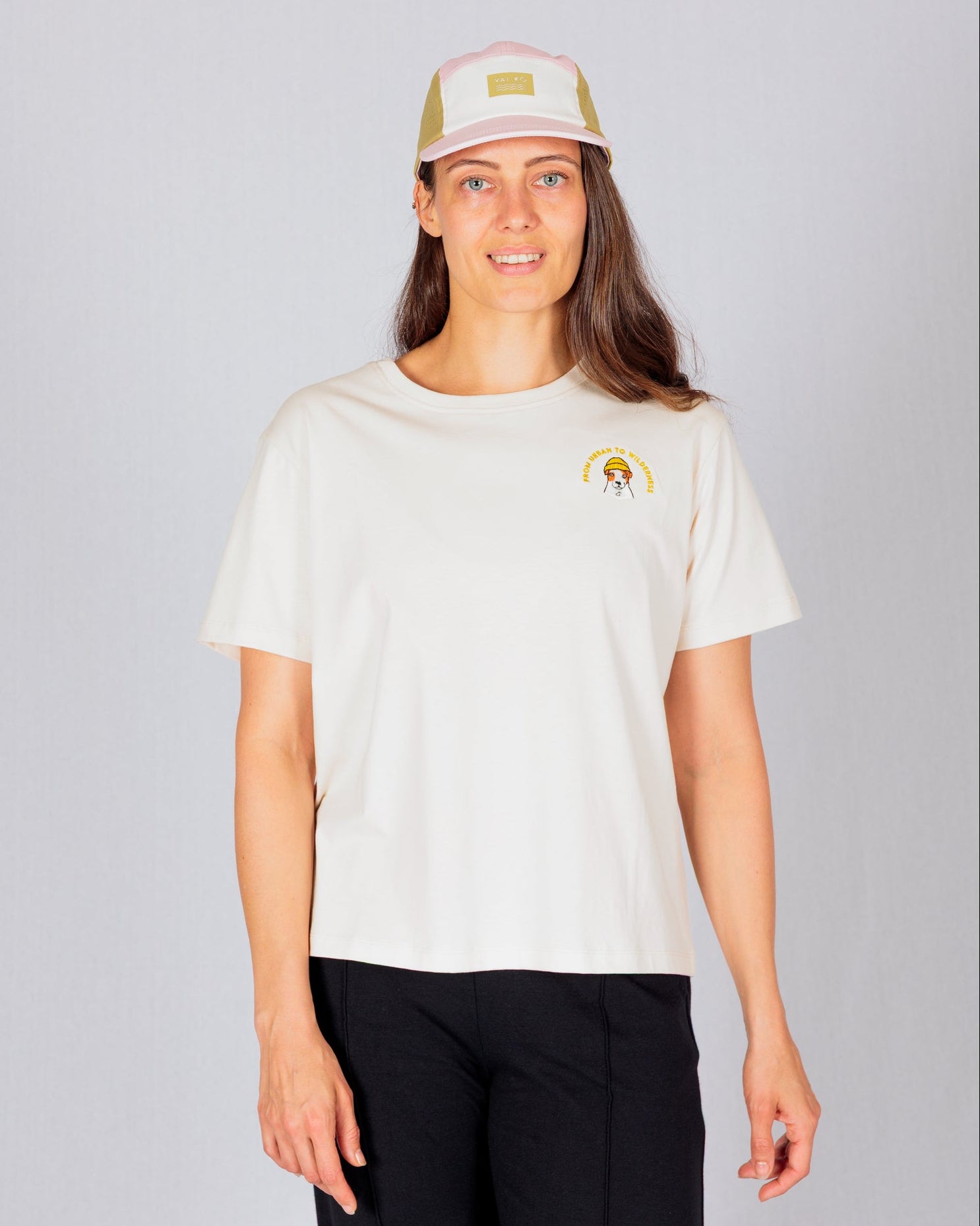 A woman wearing a white shirt and a hat.