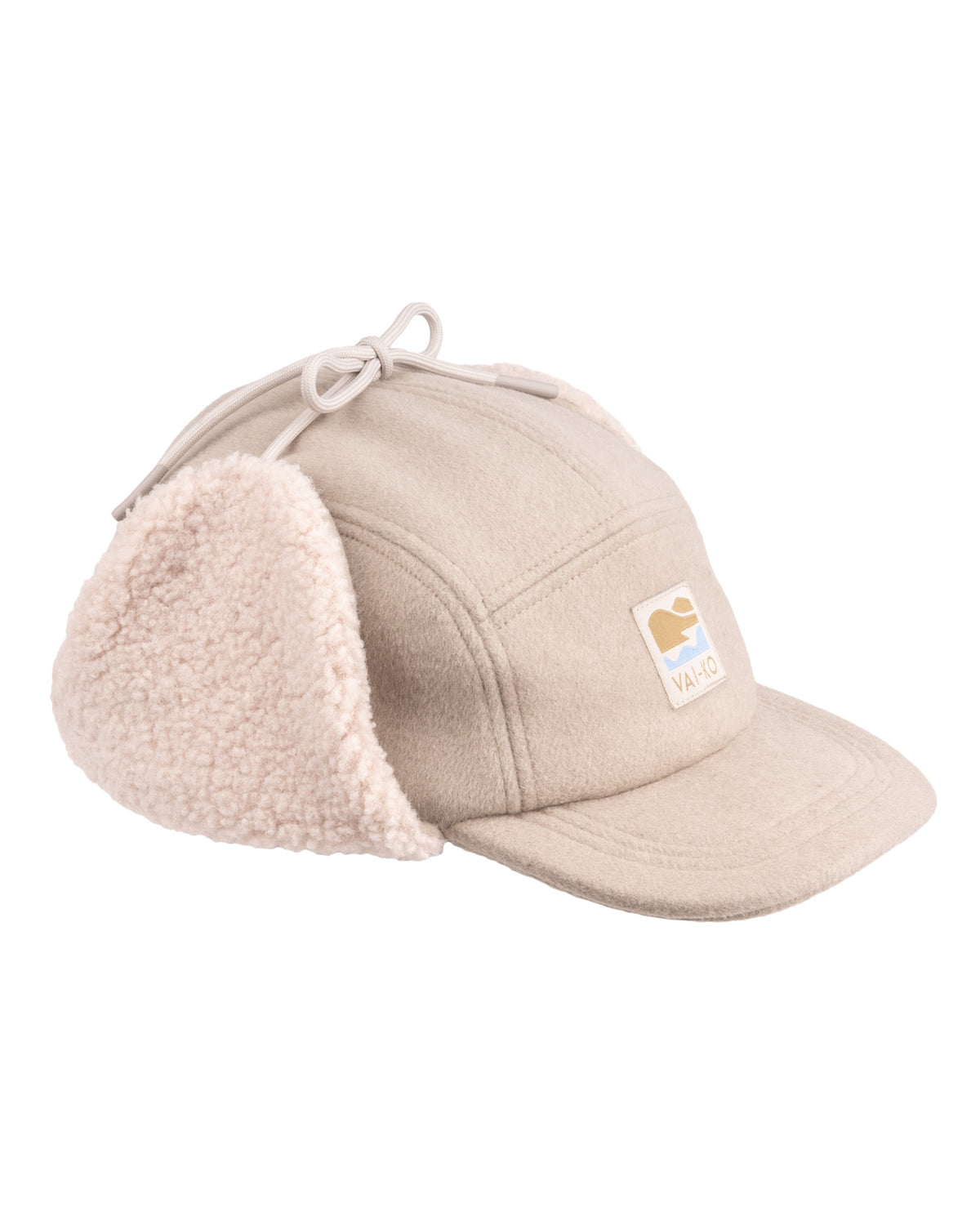 Beige winter cap with ear flaps, drawstring on top, and a small logo patch on the front.