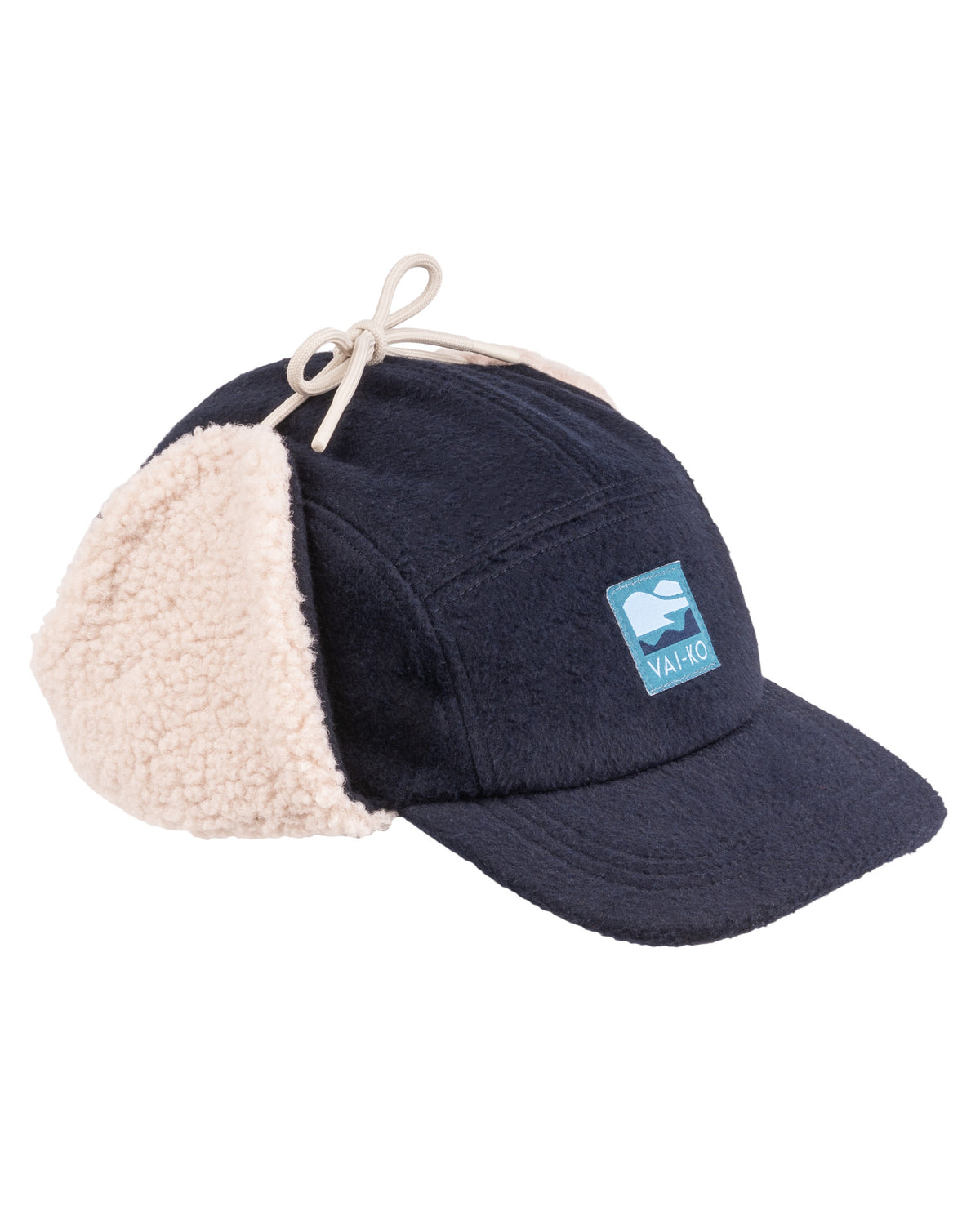 Navy cap with cream shearling ear flaps, a logo patch, and a beige drawstring on top.