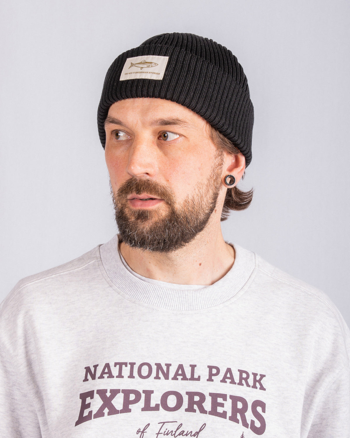 Man with a beard wearing a black beanie and a light gray National Park Explorers sweatshirt.