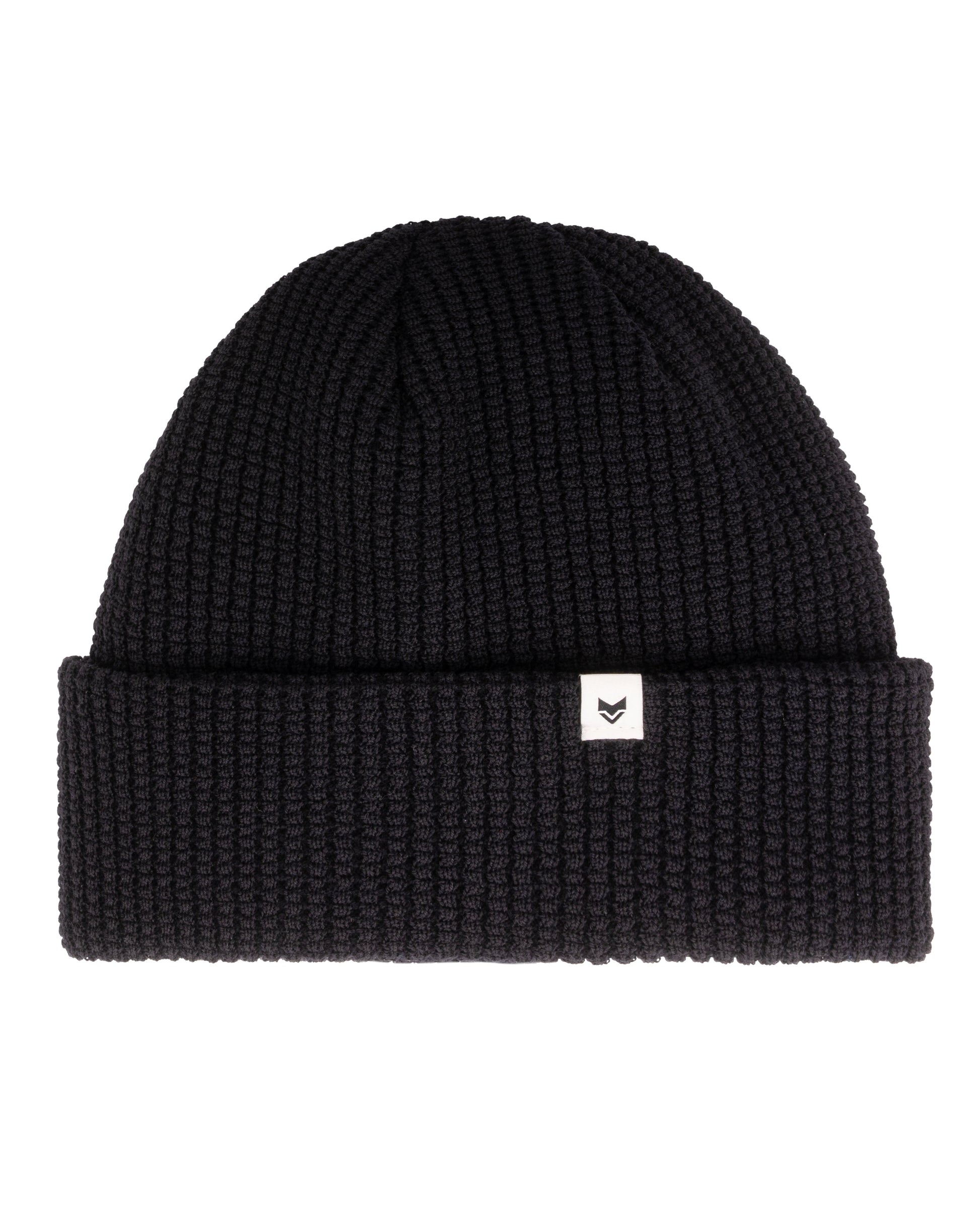 Black knit beanie with a folded brim and a small white tag featuring a simple black logo.