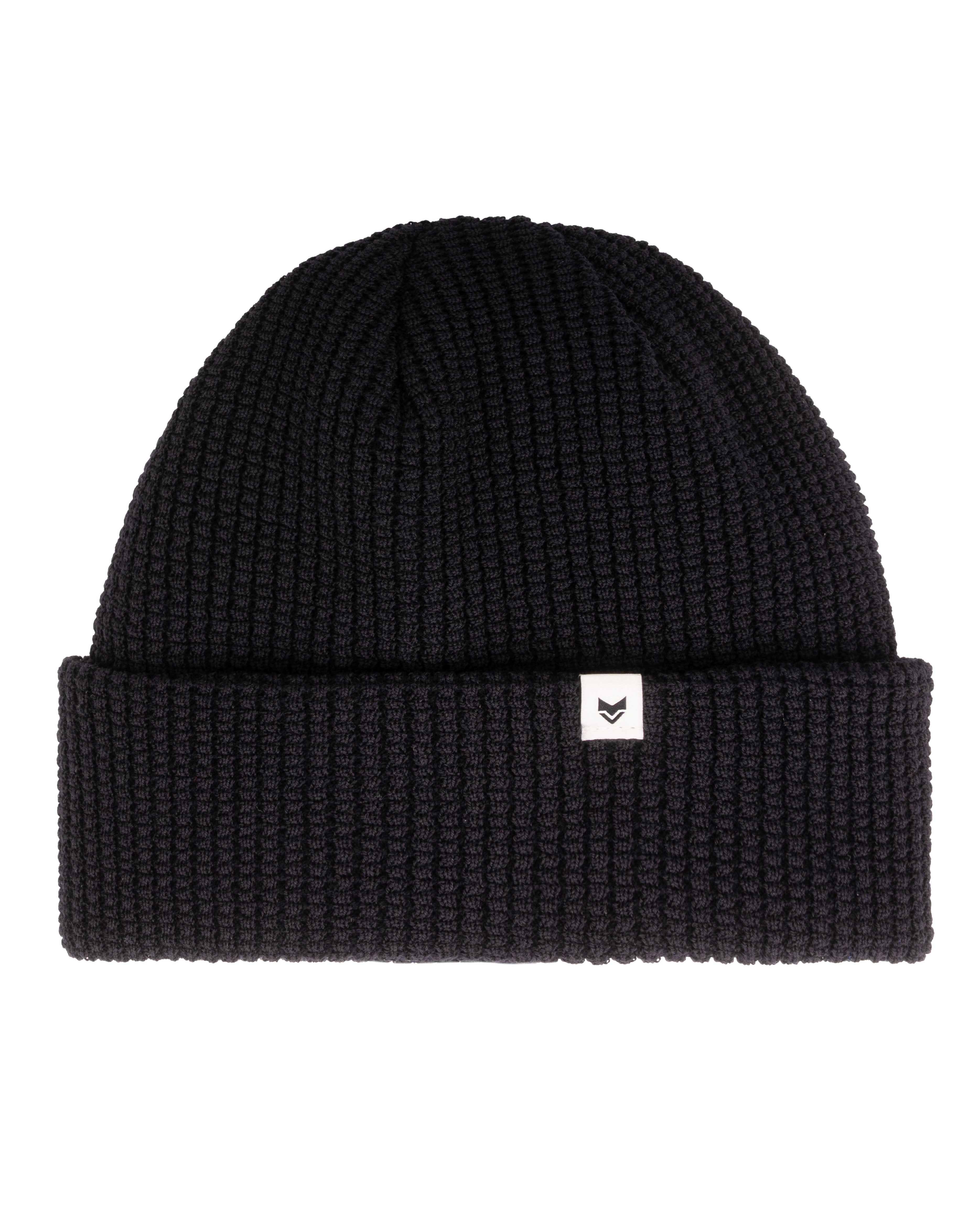 Black knit beanie with a folded brim and a small white tag featuring a simple black logo.