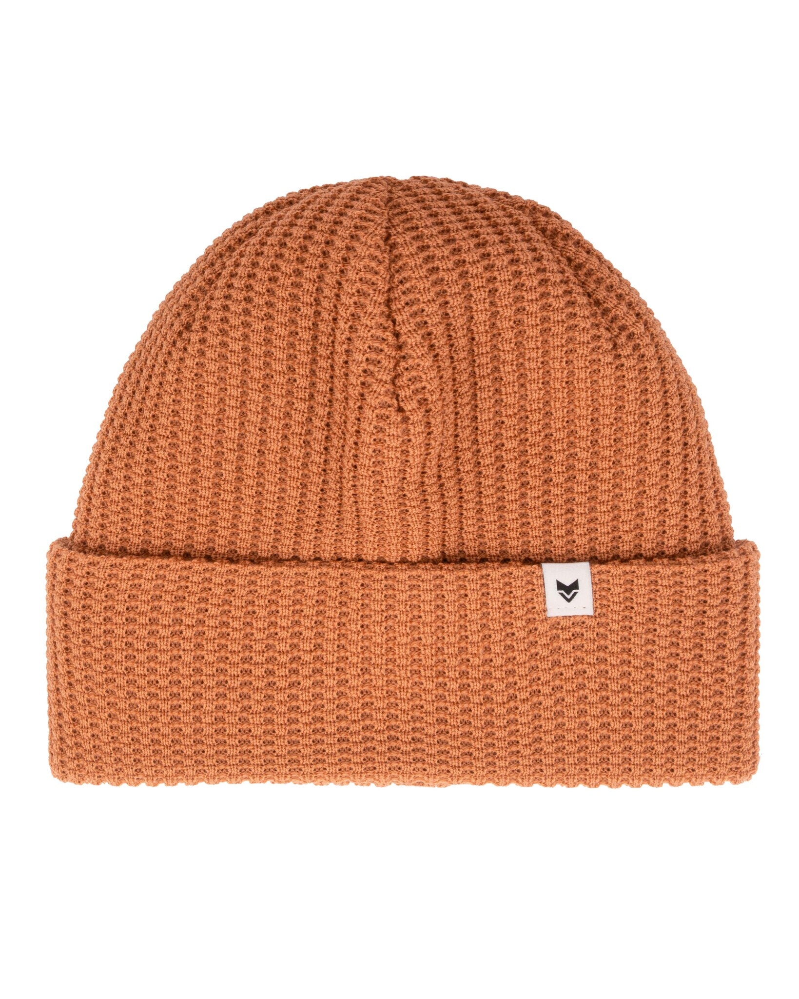 Rust orange knit beanie with a folded brim and a small white tag featuring a simple black design.